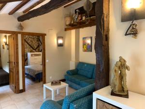 a living room with a blue couch and a bed at Apartamento Rustico El Cerezo in Lubayo