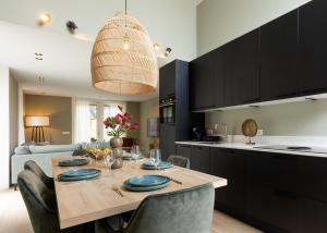 a kitchen and dining room with a table and chairs at Bos Villa met Hottub & Sauna | 8 personen - Resort Valley in Wekerom
