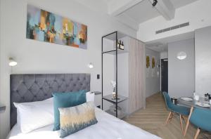 a bedroom with a bed and a table and a desk at One Thibault Hotel - Sea View Studio - Near CTICC & V&A Waterfront in Cape Town +25 photos