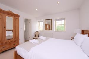 a white bedroom with two beds and a mirror at Salton Lodge Spacious Country Stay in Salton +74 photos