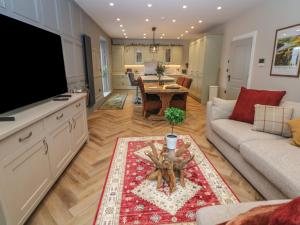 una sala de estar con un televisor y una mesa en Hunter's Lodge, en Buxton