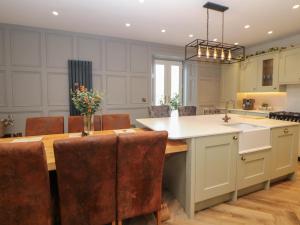 Una cocina con una mesa y sillas y un fregadero. en Hunter's Lodge, en Buxton 9 fotos más