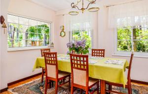 a dining room with a yellow table and chairs at Holiday Home Pobierowo Piastowska in Pobierowo