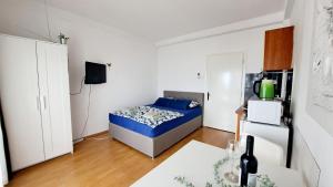 a small bedroom with a bed and a refrigerator at Apartmani E&G in Dramalj