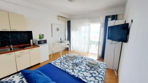 a kitchen with a blue bed in a room at Apartmani E&G in Dramalj