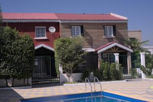 a house with a swimming pool in front of it at Résidence La Tonnelle in Antananarivo