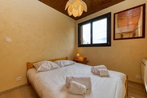 Un dormitorio con una cama con dos almohadas encima. en Homency - Résidence Les Chevreuils, en L'Alpe-d'Huez