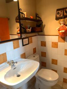 a bathroom with a white toilet and a sink at Apartamento Rustico El Cerezo in Lubayo +26 photos