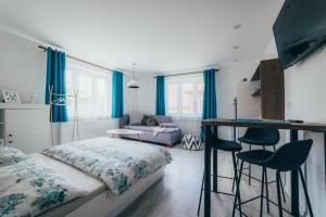 a bedroom with blue curtains and a bed and a desk at Apartmány Friends Liptov in Liptovský Mikuláš