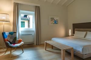 a bedroom with a bed and a chair and a table at Suite Greve in Chianti in Greve in Chianti