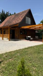 a building with a pavilion with a picnic table and benches at Căsuța cu tihnă in Porumbacu de Sus