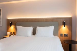 a bedroom with a large bed with white pillows at Holiday Inn Brentwood, an IHG Hotel in Brentwood