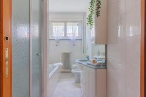 a white bathroom with a sink and a toilet at Sunflowers Home in Mandello del Lario +34 photos
