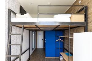 a bunk bed in a room with a blue door at Hostel Link in Lovran