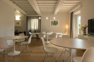 a dining room with white tables and white chairs at Suite Greve in Chianti in Greve in Chianti