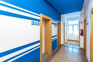 a hallway with blue and white stripes on the wall at Hostel Link in Lovran
