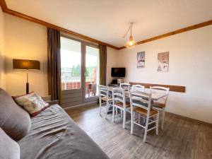 a living room with a dining room table and chairs at Homency - Résidence aux Bergers B103 in L'Alpe-d'Huez
