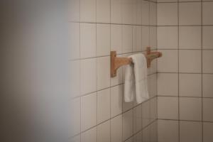 a bathroom with white tiled walls and white towels at Hotel Groede in Groede +88 photos