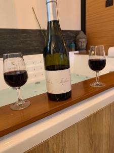 a bottle of wine and two glasses on a counter at L’atelier spa in Codognan