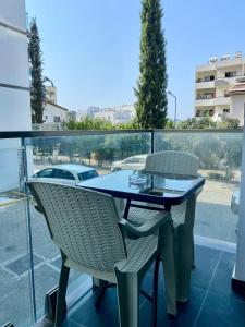 a table and chairs sitting on a balcony at Luxurious Brand New Apartment in the City Centre in Kérynia
