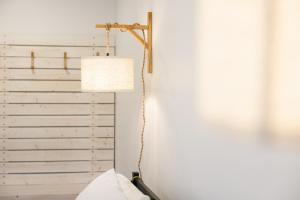 a lamp in a room with a white wall at Homeport Suites & Residences in Lords Cove 