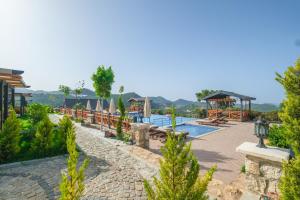 a resort with a pool and a gazebo at Kaş Konak Bungalows in Kaş