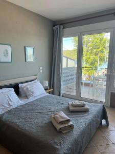 a bedroom with a bed with two towels on it at Glykanisos Mini Suites in N&eacute;a P&eacute;ramos