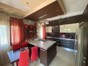 a kitchen with a counter and red chairs in it at SpitiAyia in Ayiá