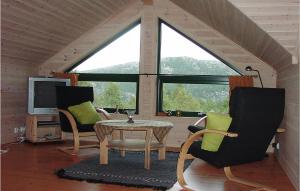 a living room with a table and chairs and a large window at 5 Bedroom Awesome Home In Kvinlog in Stakkeland