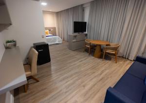 戈亚尼亚Rota 44 Hotel的一间带床和桌子的房间的客厅
