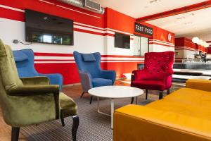 a waiting room with colorful chairs and a table at Hostel Link in Lovran