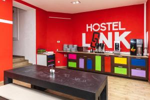 a room with a red wall with a hostelel lk sign at Hostel Link in Lovran