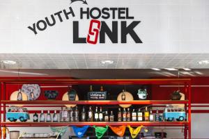 a room with a shelf with bottles of alcohol at Hostel Link in Lovran