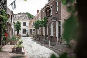 an old cobblestone street in a town with buildings at Hotel Groede in Groede