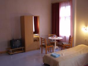 a bedroom with a bed and a table and a television at Tiia Guesthouse in Pärnu