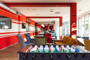 a room with a foosball table and chairs at Hostel Link in Lovran