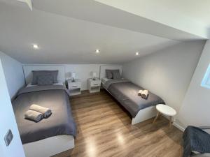 two beds in a room with wooden floors at Kuća za odmor Mariola in Karlovac
