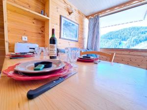 - une table avec une bouteille de vin et des verres dans l'établissement Studio rénové pied des pistes à Pra-Loup 1600 - FR-1-165A-29, à Uvernet