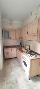 a kitchen with wooden cabinets and a white stove top oven at Iaru-Bed Experience House in Alberobello +45 photos