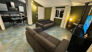 un salon avec un canapé et une télévision dans l'établissement Moonlight house a 50 mt dal mare Noto Marina, à Noto Marina
