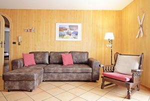 una sala de estar con un sofá y una silla en CASA DOLOMIA - Agenzia Dolomiti Affitti, en Cavalese