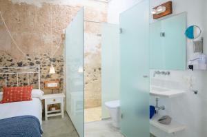 ein kleines Badezimmer mit einem Bett und einem Waschbecken in der Unterkunft Casa el Alto - Lava in Punta de Mujeres + 21 Fotos