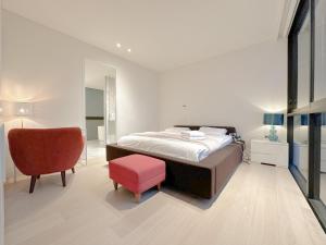 シドニーにあるPyrmont Guest House Air-Conのベッドと赤い椅子のある寝室
