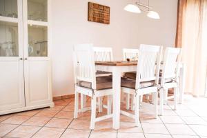 a white dining room with a table and chairs at Ferienhaus Achtern Diek in Schönberg