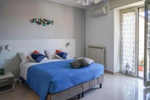 a bedroom with a bed with a blue blanket at Nonna Carmela Holiday House in San Lazzaro Agerola