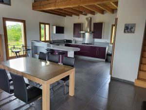 a kitchen with a table and chairs in a room at Villa avec magnifique point de vue 230 m2 in Blars