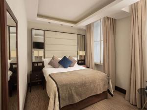 a hotel room with a large bed with blue pillows at Montcalm Brewery, London City in London