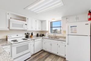 a white kitchen with white appliances and a window at The Sands Condos in Gulf Shores +87 photos