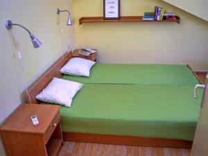 una camera ospedaliera con un letto verde e una lampada di Apartments Anna a Zara (Zadar)