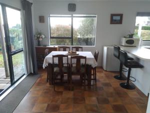 a kitchen and dining room with a table and chairs at Arawai - Waimarama Holiday Home in Waimarama +6 photos